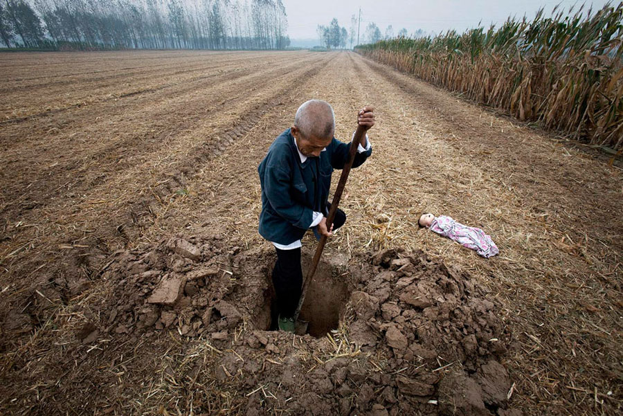 Un granjero cava la tumba para enterrar a un niño hallado muerto, 2010. © Lu Guang