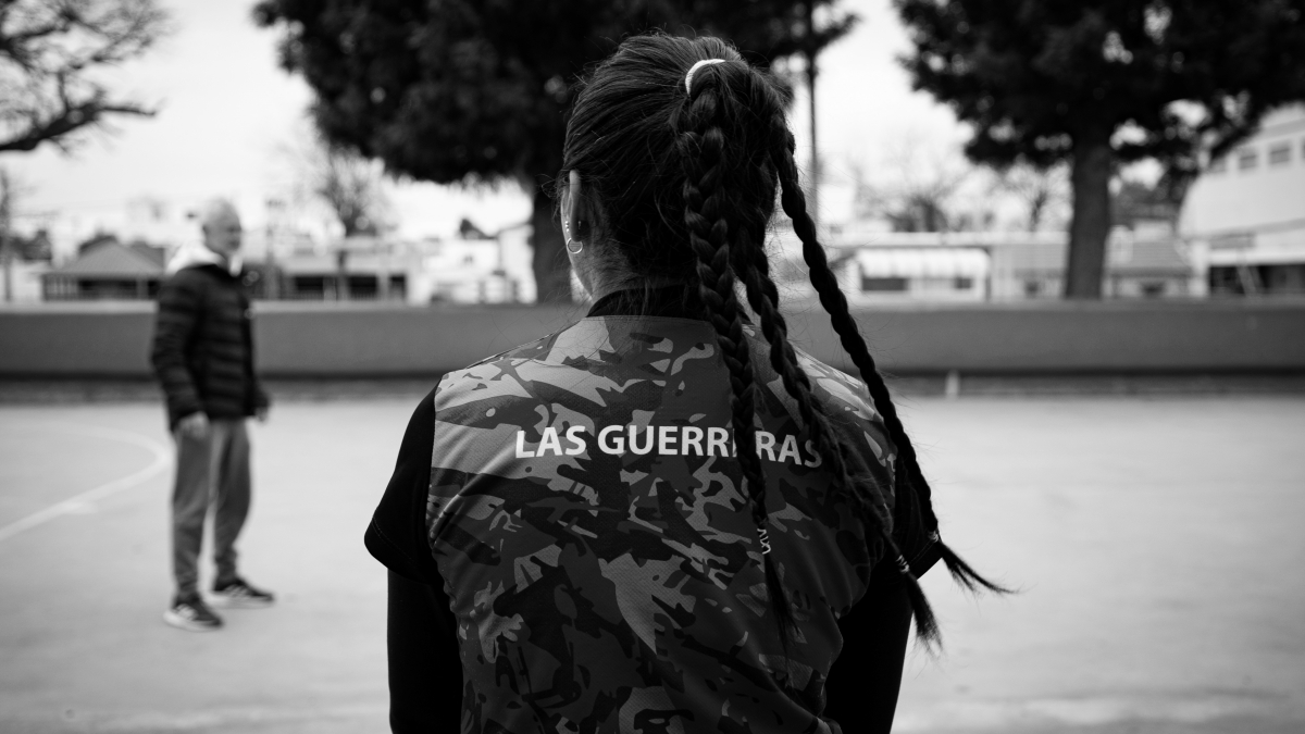Una jugadora de fútbol de espaldas a la cámara con una camiseta que dice "Las Guerreras".